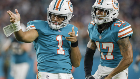 Miami Dolphins quarterback Tua Tagovailoa celebrates with teammate Jaylen Waddle after running for a first down in the team’s win versus the New England Patriots.