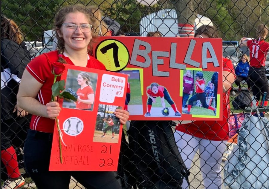 Bella Converyposes with her sign and card celebrating her seasons of hard work and lots of fun. 