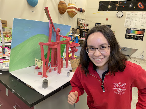 Hana Shinzawa 24 poses with her cross-country theme roller coaster which the juniors create in physics to learn about kinetic energy.