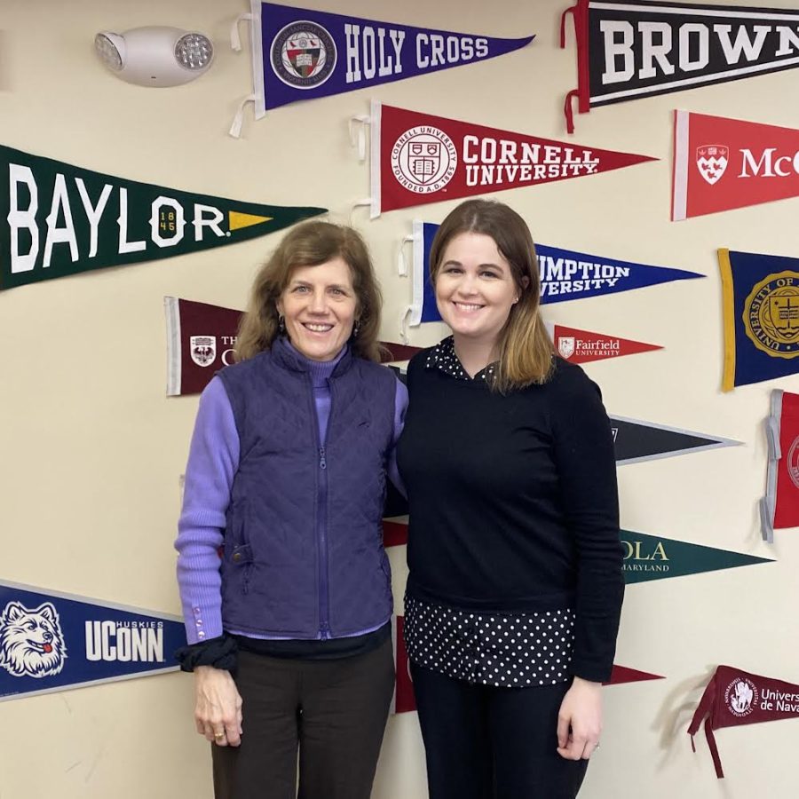 Mrs Foley and Dr Millay pose in front of the wall of college banners.