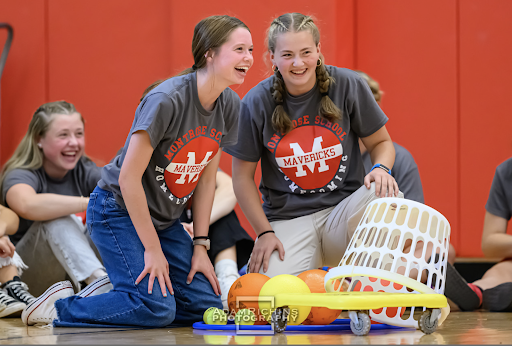 White team leaders (left to right) Cate Lynch ‘24 and Leslie Baker ‘24, round up their earnings in a competitive real-life hungry-hungry-hippos game at the Homecoming pep rally. 