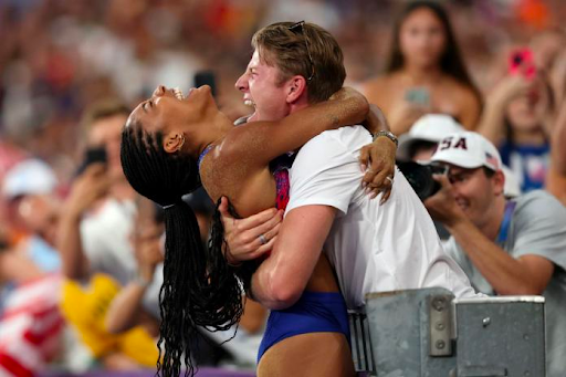 Tara and Hunter Woodhall embrace after Tara secures a gold medal at the Paris 2024 Olympics. 