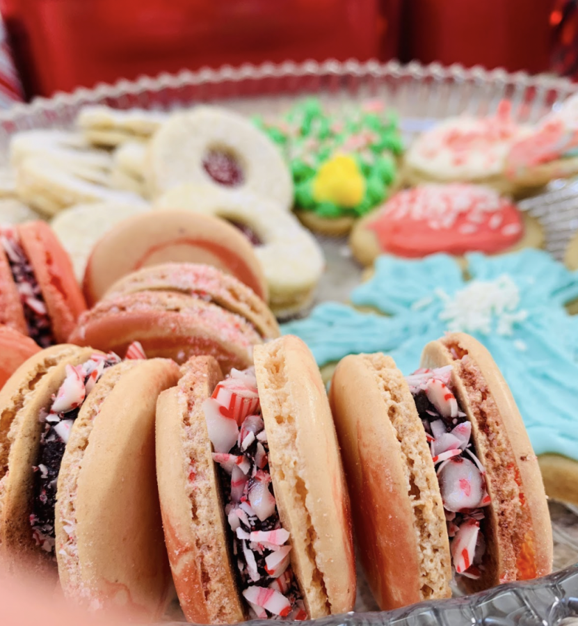 A plate of delicious peppermint macarons and an assortment of other Christmas cookies.