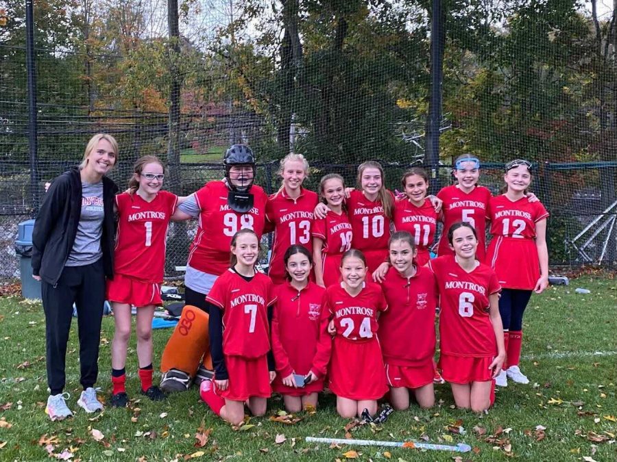 The+fall+2021+JV+field+hockey+team+with+Coach+Moran+after+a+game.