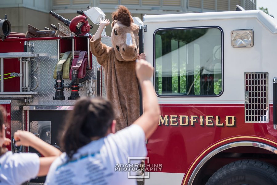 Montrose Mascot Monty waving at seniors from a Medfield firetruck.
