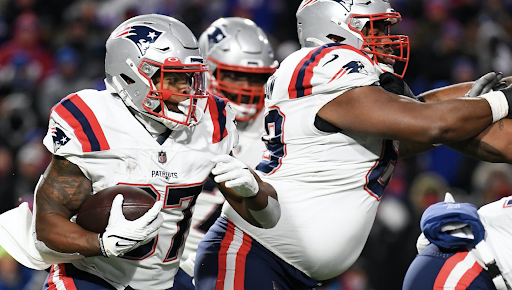 Patriots running back Damien Harris runs with the ball during the first half.